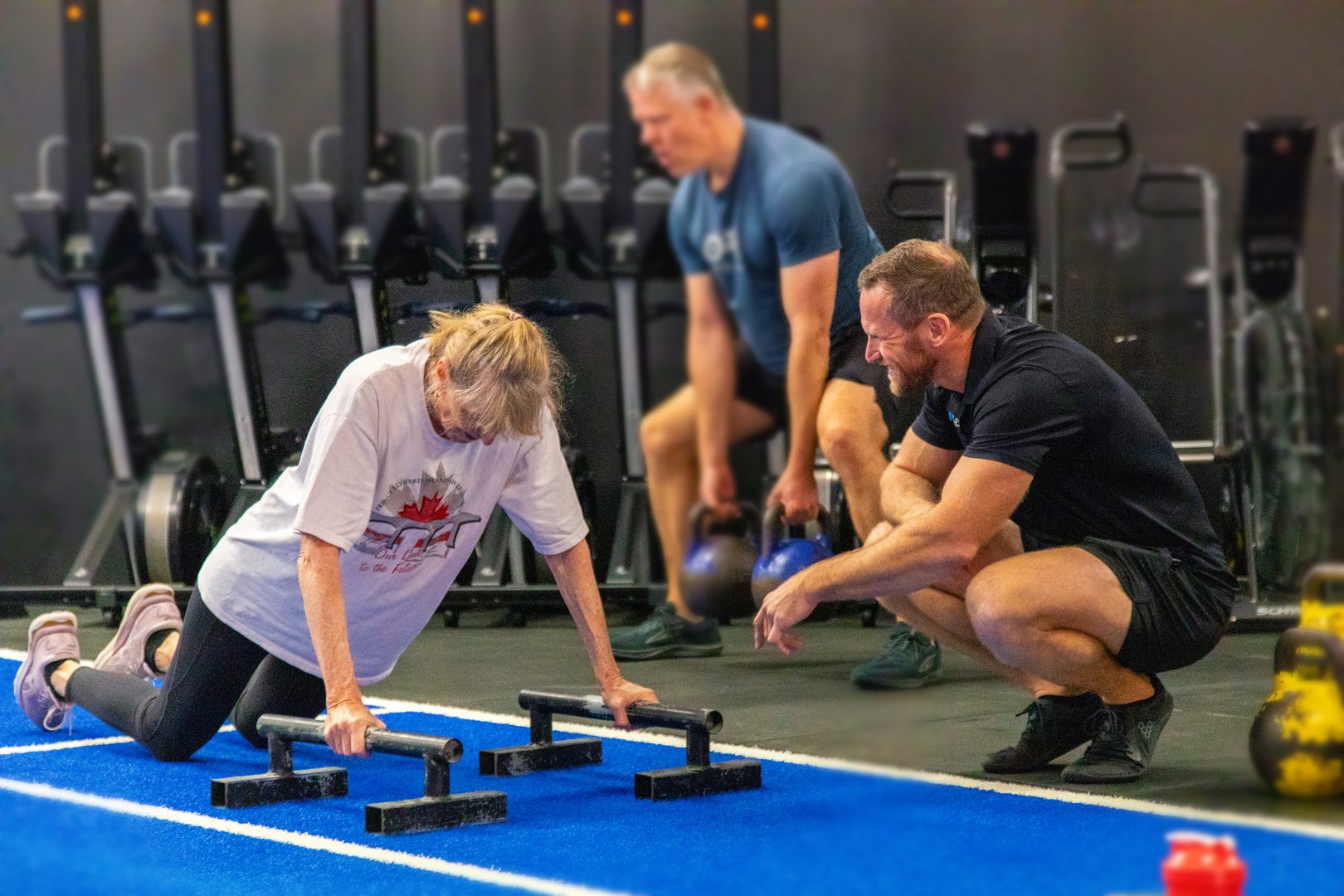 Coach working one-on-one with an older member at floor level